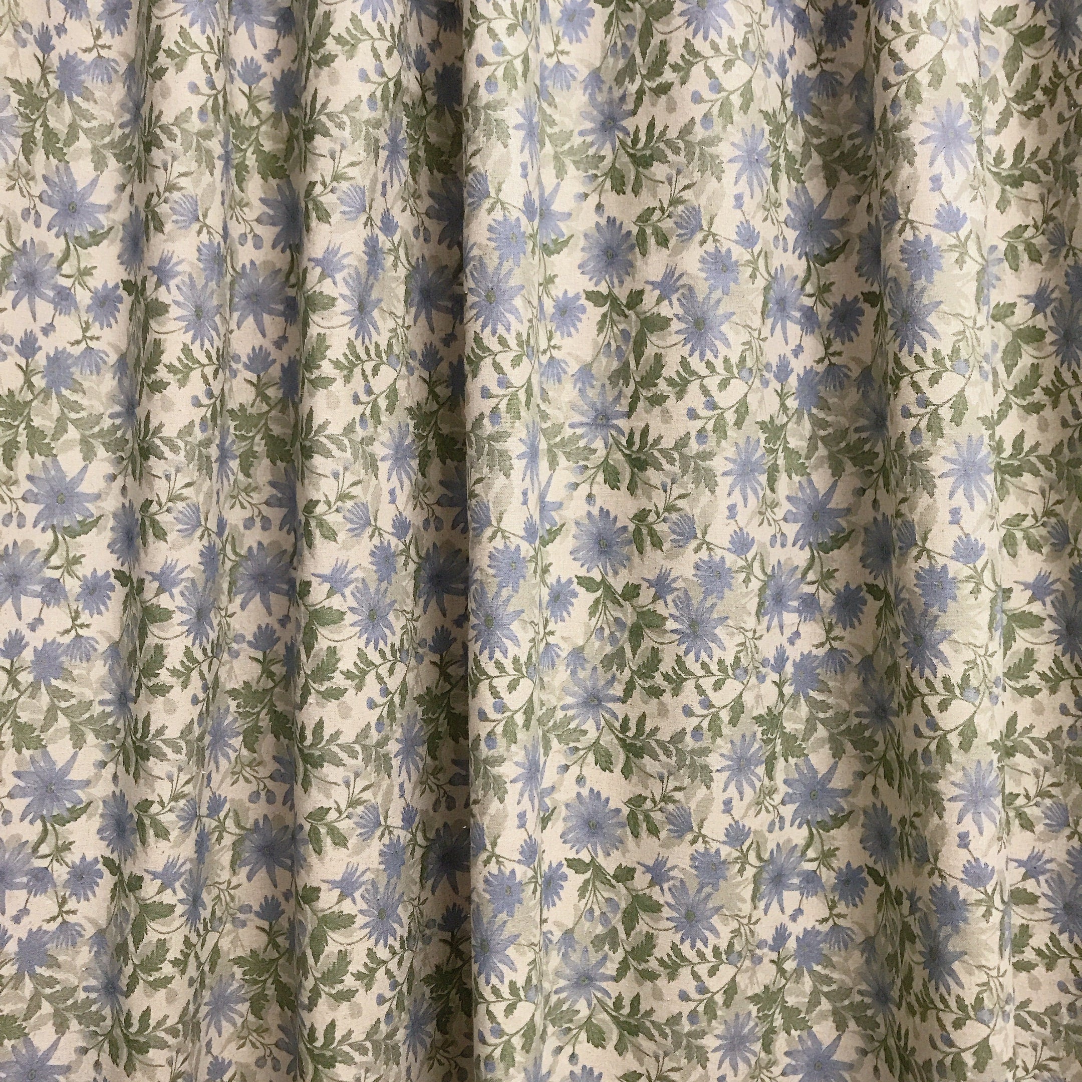 Rideau fleuri bleu pâle et sauge sur fond beige naturel