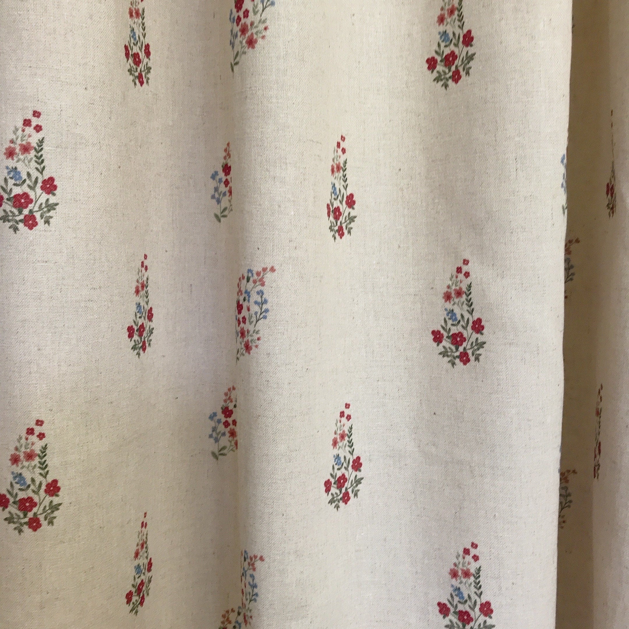 Rideau fleuri rouge et rose framboise sur fond beige naturel