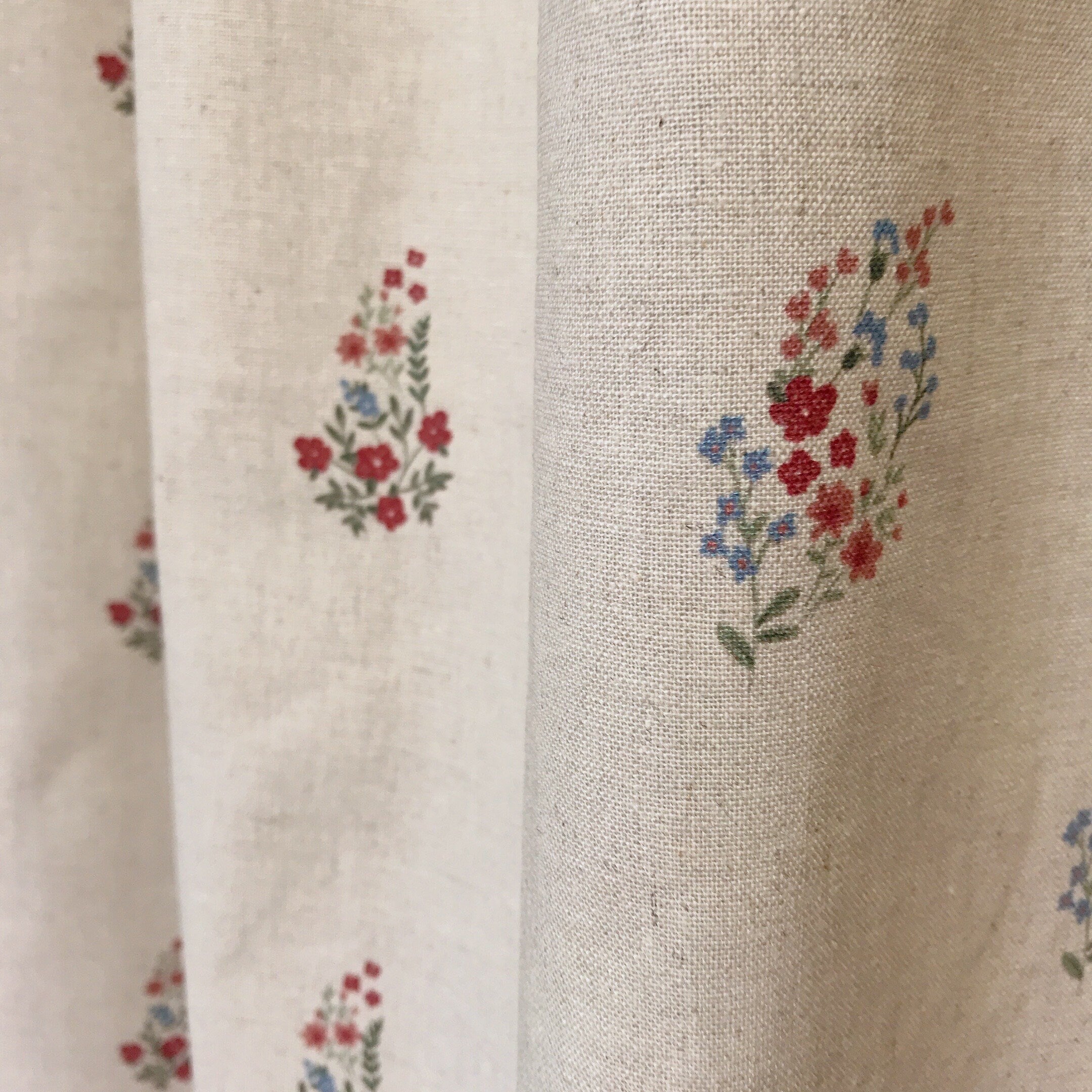 Rideau fleuri rouge et rose framboise sur fond beige naturel